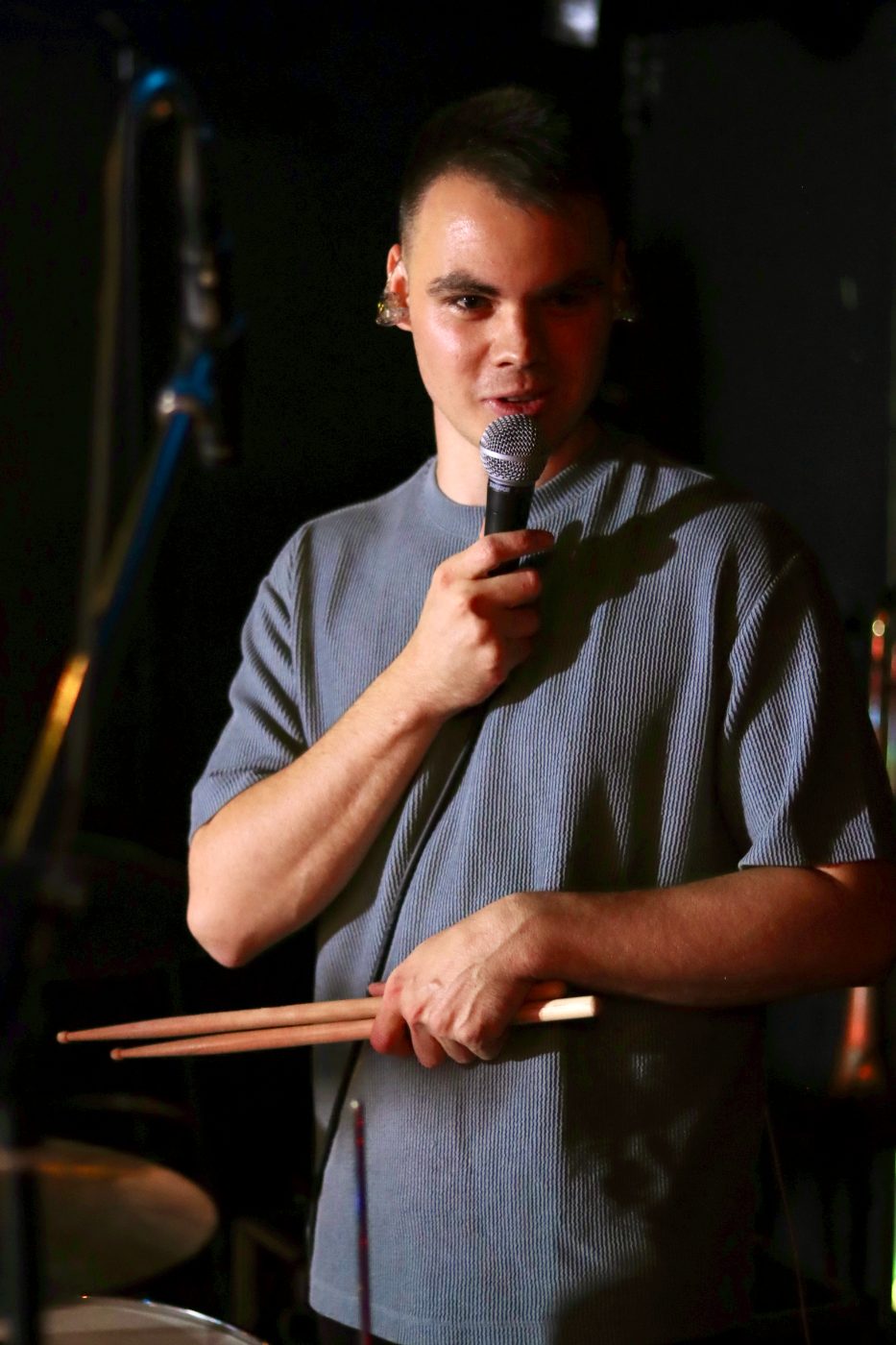 Dennis Aubele am Mikrofon hinter dem Drumset
