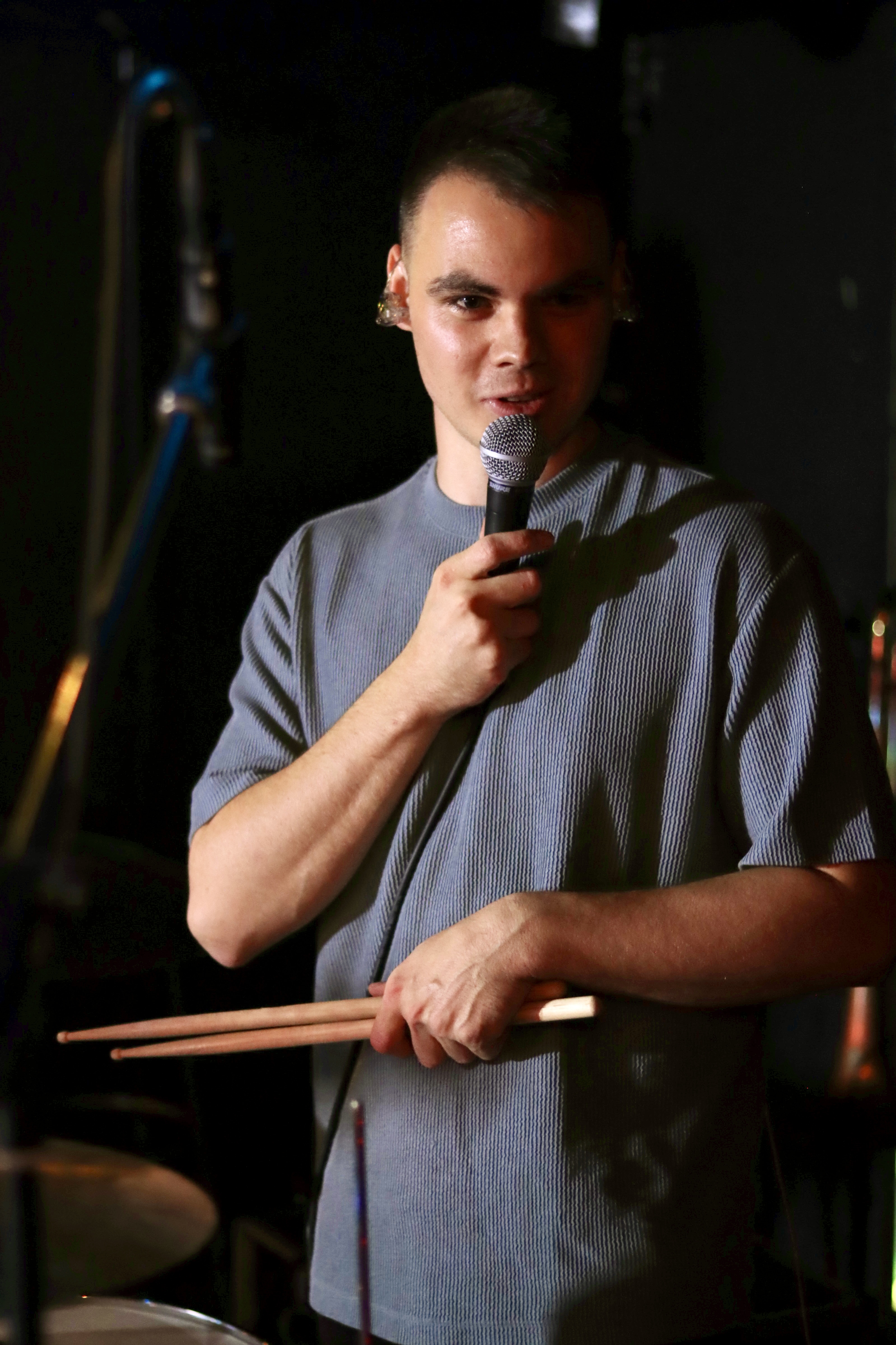 Dennis Aubele am Mikrofon hinter dem Drumset